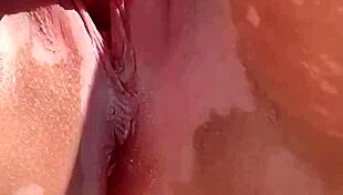 A naked woman masturbates her shaved pussy in the garden