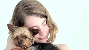 hot naked blonde cuddles her puppy in a tender moment