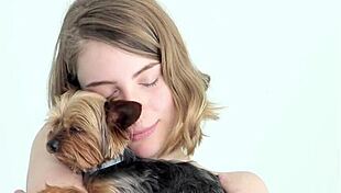 hot naked blonde cuddles her puppy in a tender moment