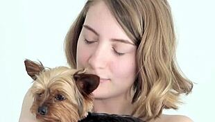 hot naked blonde cuddles her puppy in a tender moment