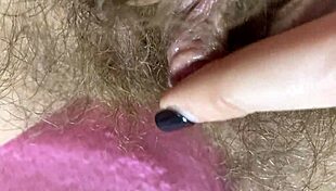 Extreme close-up of wet hairy pussy with big clit rubbing to orgasm
