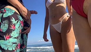 Jerking off on the beach while sexy girls join to help.