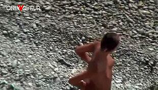 At the beach, a hot babe flashes her natural tits and ass with a buttplug for voyeurs.