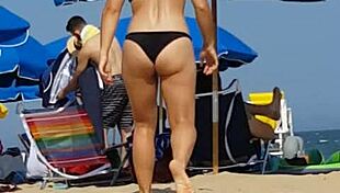 Check out this candid shot of the little slut's ass in bikini at the beach.