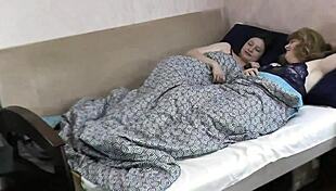 I see two women kissing in bed, big natural tits and all.