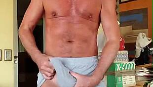 bodybuilder rubs boner bulge in shorts