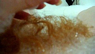 annie relaxes in the bath, fingering her hairy pussy