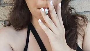 kelly kendricks smokes in the sun, showing lots of cleavage 😎
