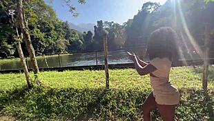 Ebony goddess teases her sweet spot outdoors by the waterfall